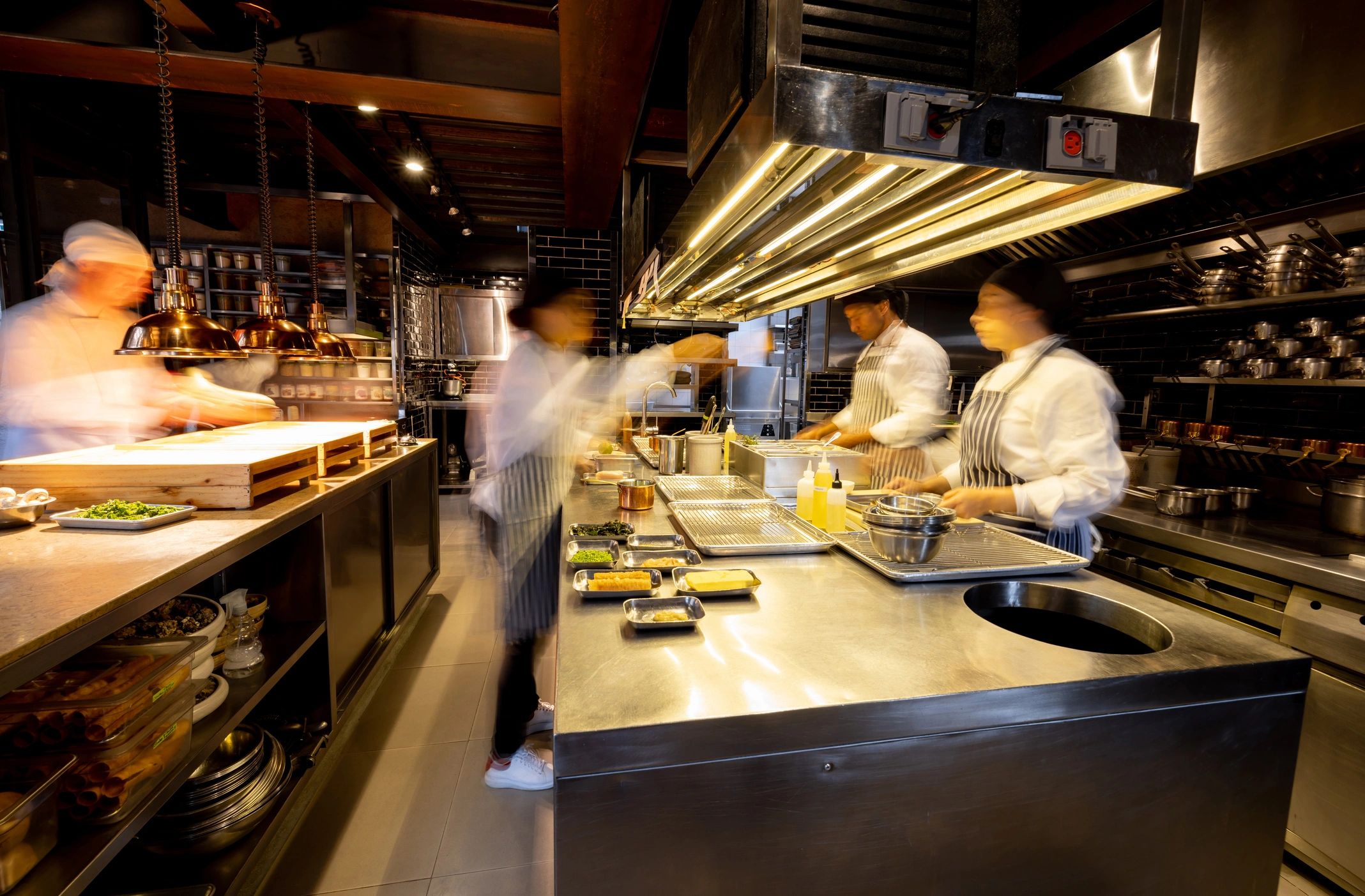 Equipo de cocina preparando tlayudas en ambiente moderno